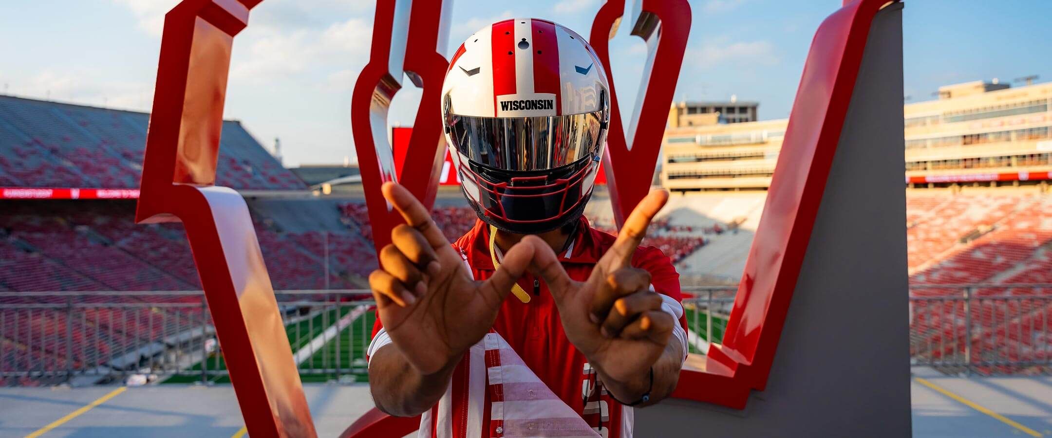 Sundaramoorthy throws a "W" in a Badger football-themed racing helmet.