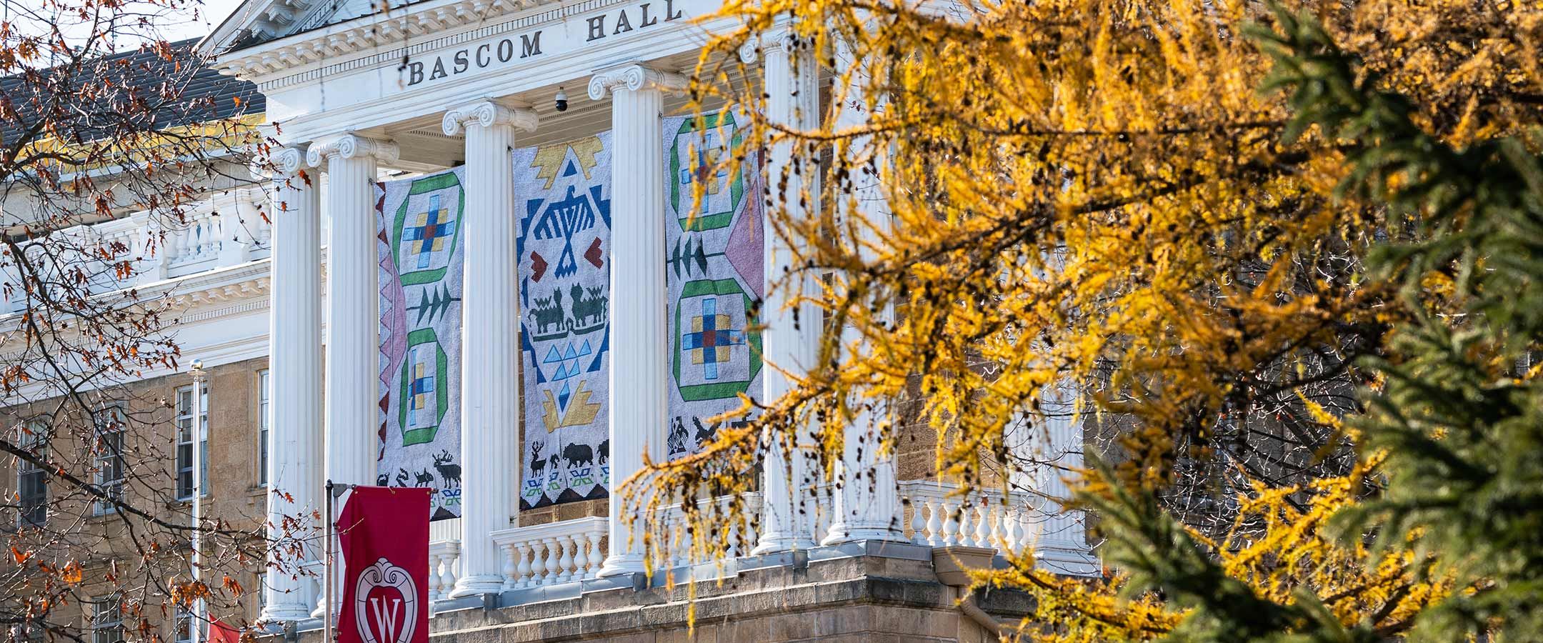 Seed by Seed banners, inspired by traditional Ho-Chunk beading, hang in front of Bascom Hall.