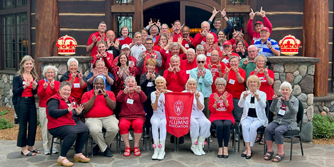 A crowd of alumi attendees posing together at alumni college.